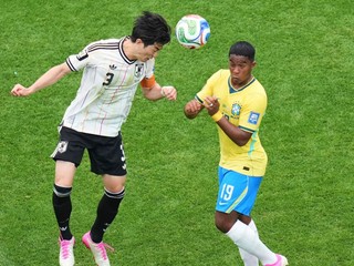Japonec Shogo Taniguchi (3), vľavo, sa vrhá po lopte spolu s Brazílčanom Endrickom (19)