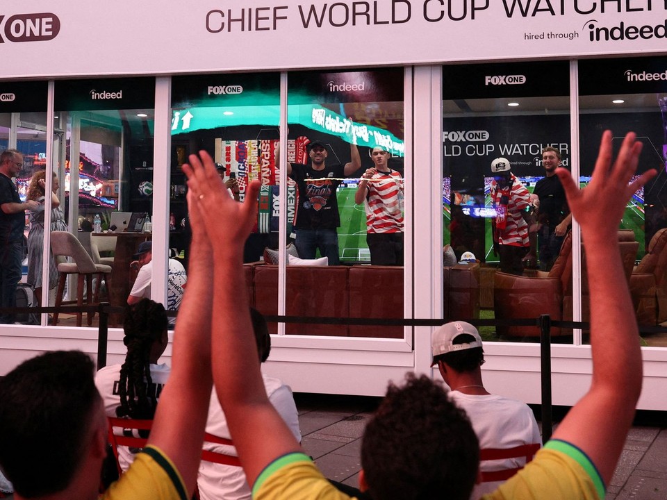 Dvaja muži pozerajú všetky zápasy v presklenej miestnosti na Times Square