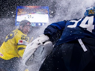 Elias Lindholm zo Švédska a brankár Fínska Juuse Saros v zápase MS 2025 v hokeji.