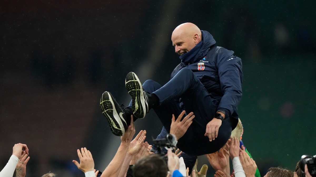 Nórski futbalisti vyhadzujú nad hlavy trénera Staaleho Solbakkena po postupe na MS 2026. 