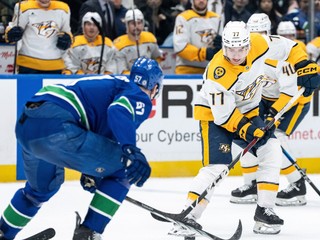 Luke Evangelista (77) s pukom na hokejke sa snaží vyhnúť hráčovi Vancouveru.