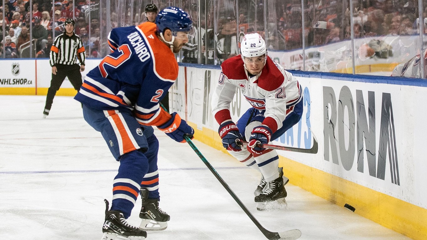 Juraj Slafkovský (Montreal) a Evan Bouchard (Edmonton) v súboji pri mantineli. 