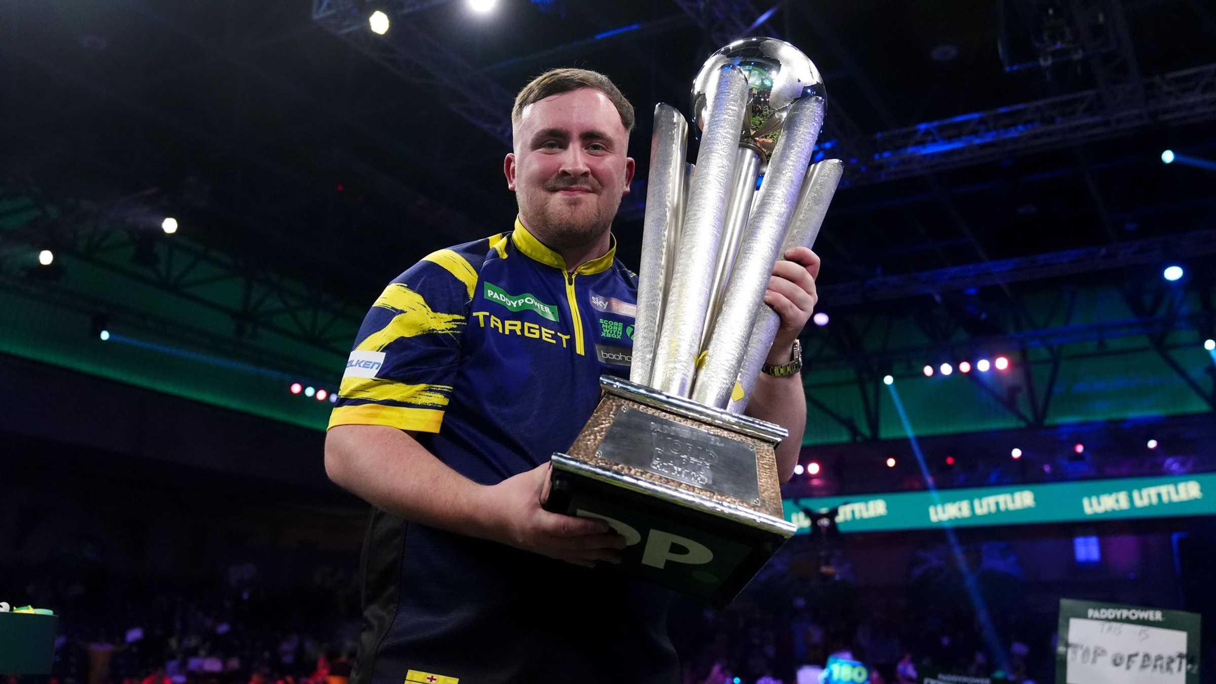 Angličan Luke Littler drží v rukách trofej Sida Waddella po triumfe na MS v šípkach 2026.