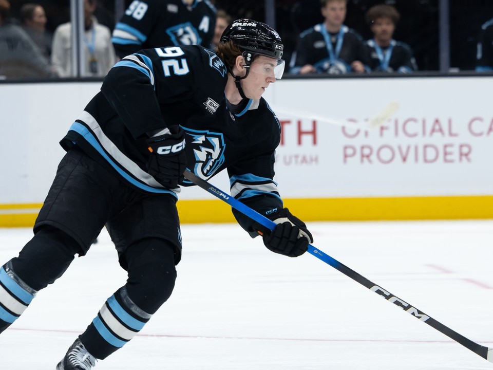 Logan Cooley z Utahu Mammoth s pukom počas zápasu zámorskej NHL Utah Mammoth - Vegas Golden Knights.