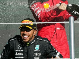 Pretekár tímu Ferrari Charles Leclerc strieka šampanské na Lewisa Hamiltona. 