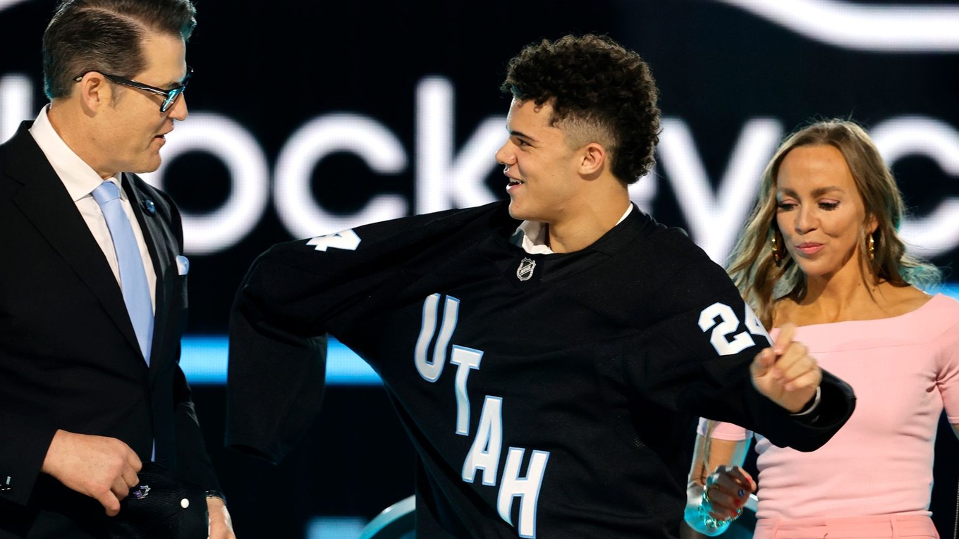 Tij Iginla, center, puts on a jersey after being selected by the Utah Hockey Club during the first round round of the NHL hockey draft Friday, June 28, 2024, in Las Vegas. (AP Photo/Steve Marcus)