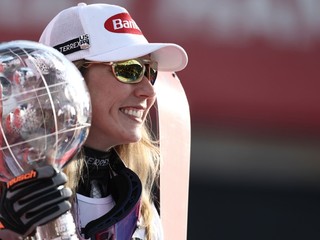 Mikaela Shiffrinová pózuje na pódiu s veľkým glóbusom