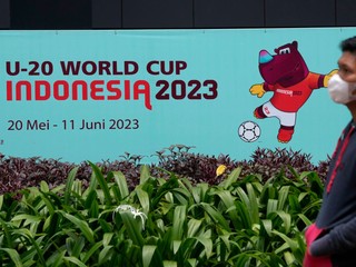 Muž kráča okolo reklamného pútača MS do 20 rokov 2023, ktoré mala hostiť Indonézia.