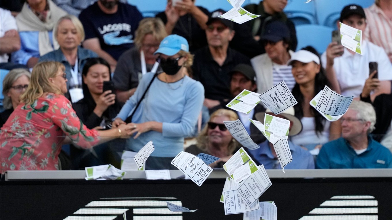 Žena hádže z hľadiska do arény letáky počas zápasu Australian Open