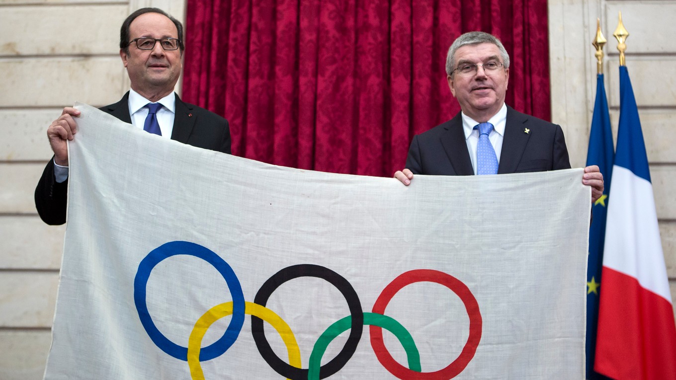 Šéf MOV Thomas Bach (vpravo) a francúzsky prezident Francois Hollande držia v rukách olympijskú vlajku z hier v roku 1924.. 
