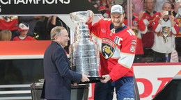 Kapitán Floridy Aleksander Barkov (vpravo) a komisár hokejovej NHL Gary Bettman držia Stanleyho pohár.