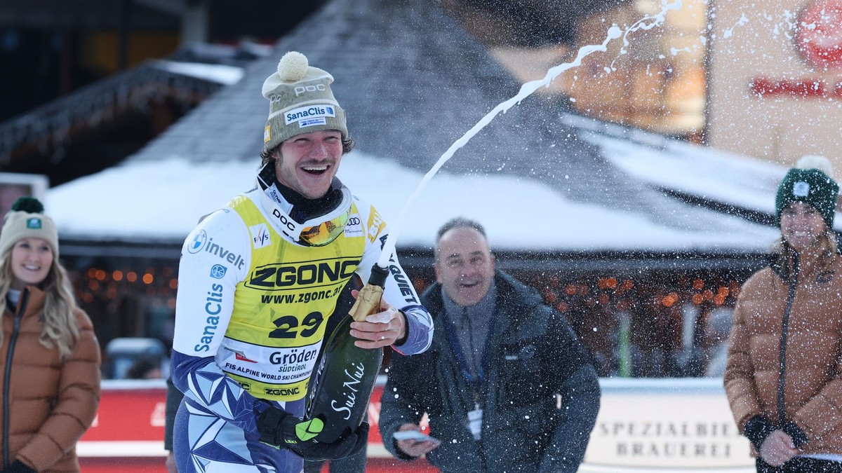 Český lyžiar Jan Zabystřan oslavuje so šampanským po jeho víťazstve v super-G.