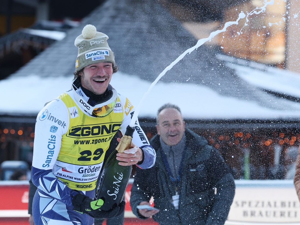 Český lyžiar Jan Zabystřan oslavuje so šampanským po jeho víťazstve v super-G.