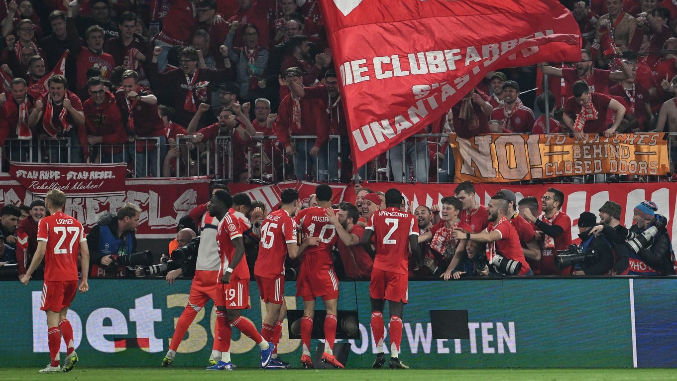 Hráči Bayernu oslavujú gól s fanúšikmi.