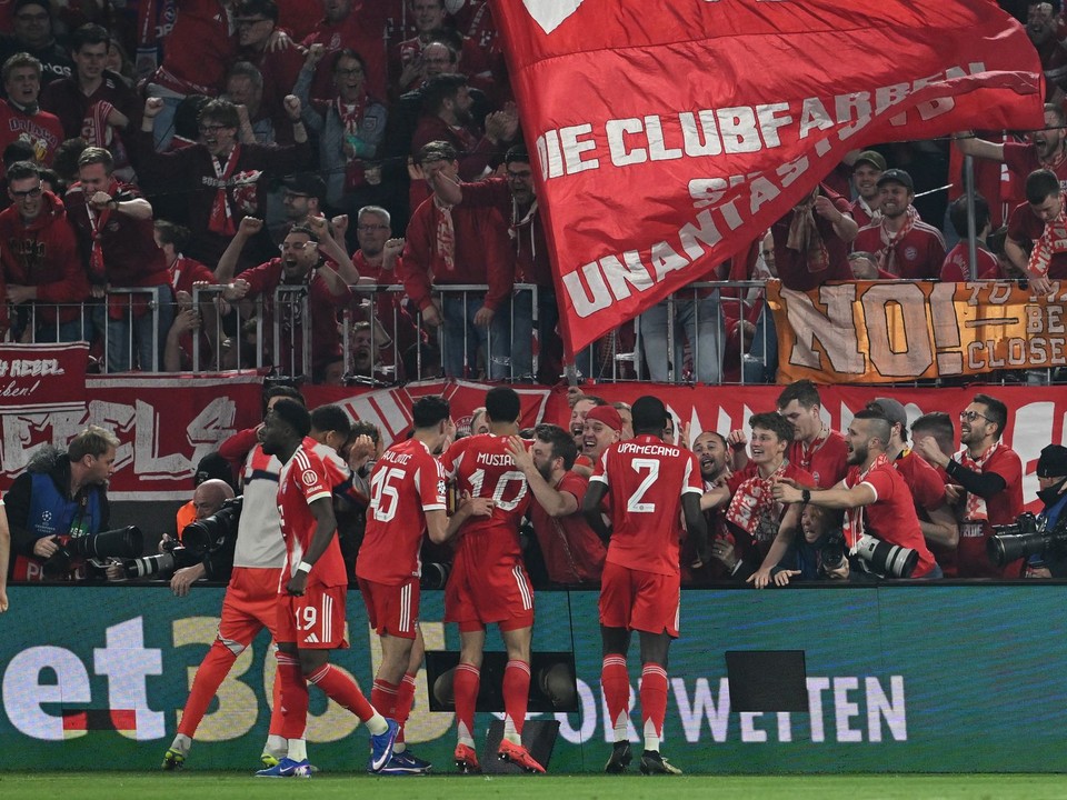Hráči Bayernu oslavujú gól s fanúšikmi.