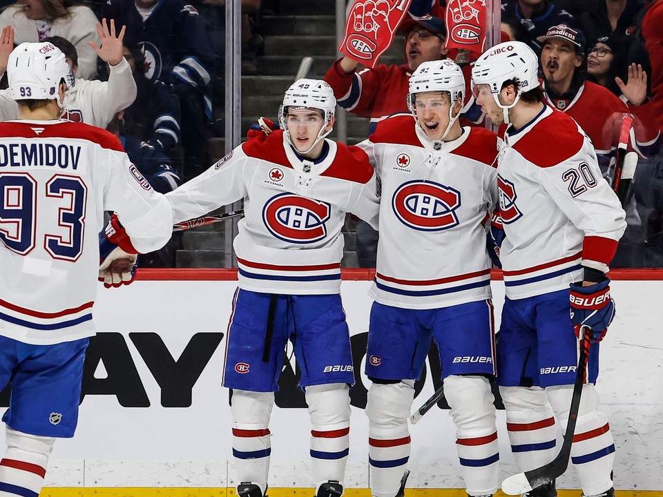 Juraj Slafkovský (vpravo) oslavuje gól so spoluhráčmi