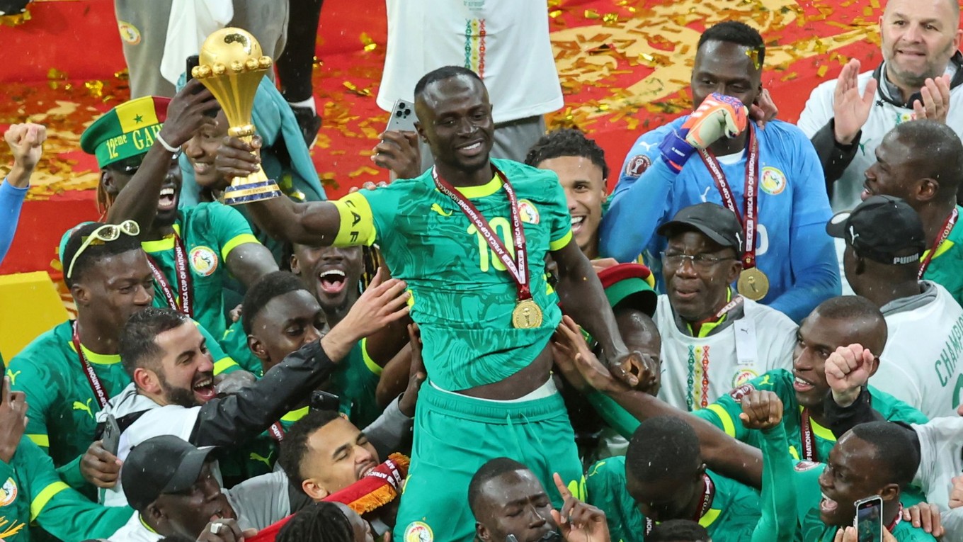 Sadio Mané zo Senegalu drží trofej nad hlavou a oslavuje so spoluhráčmi po víťazstve vo finále.