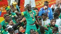Sadio Mané zo Senegalu drží trofej nad hlavou a oslavuje so spoluhráčmi po víťazstve vo finále.