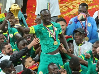 Sadio Mané zo Senegalu drží trofej nad hlavou a oslavuje so spoluhráčmi po víťazstve vo finále.