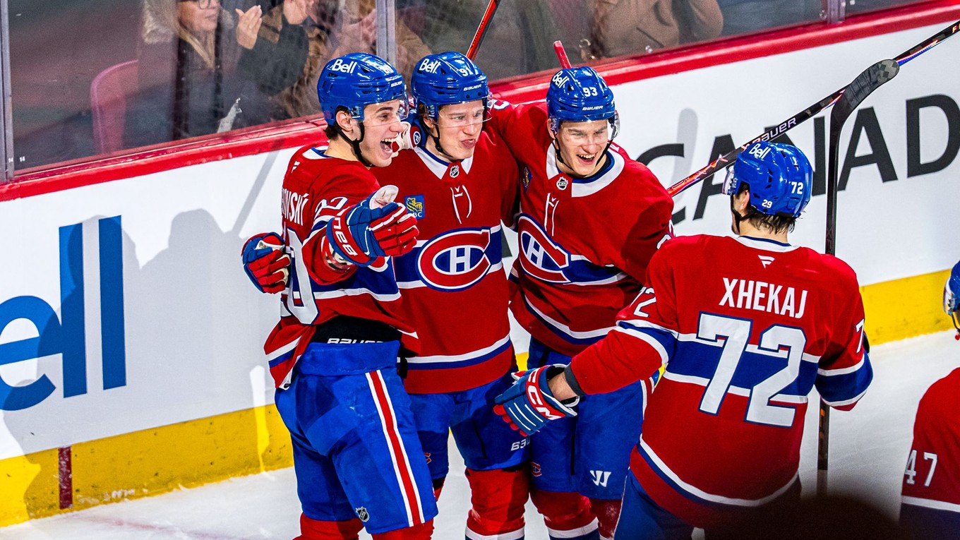 Juraj Slafkovský oslavuje so spoluhráčmi gól. 