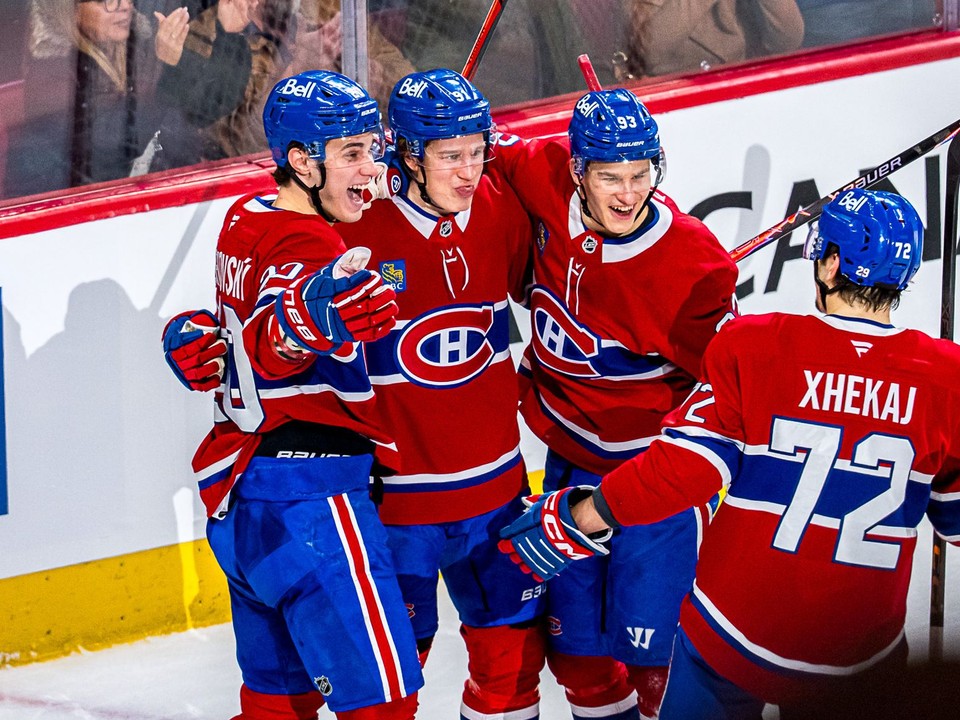 Juraj Slafkovský oslavuje so spoluhráčmi gól.