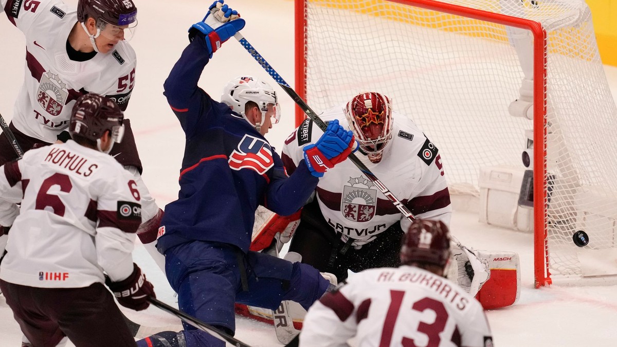 Kristers Gudlevskis a Brady Tkachuk počas zápasu Lotyšsko - USA na MS v hokeji 2024.
