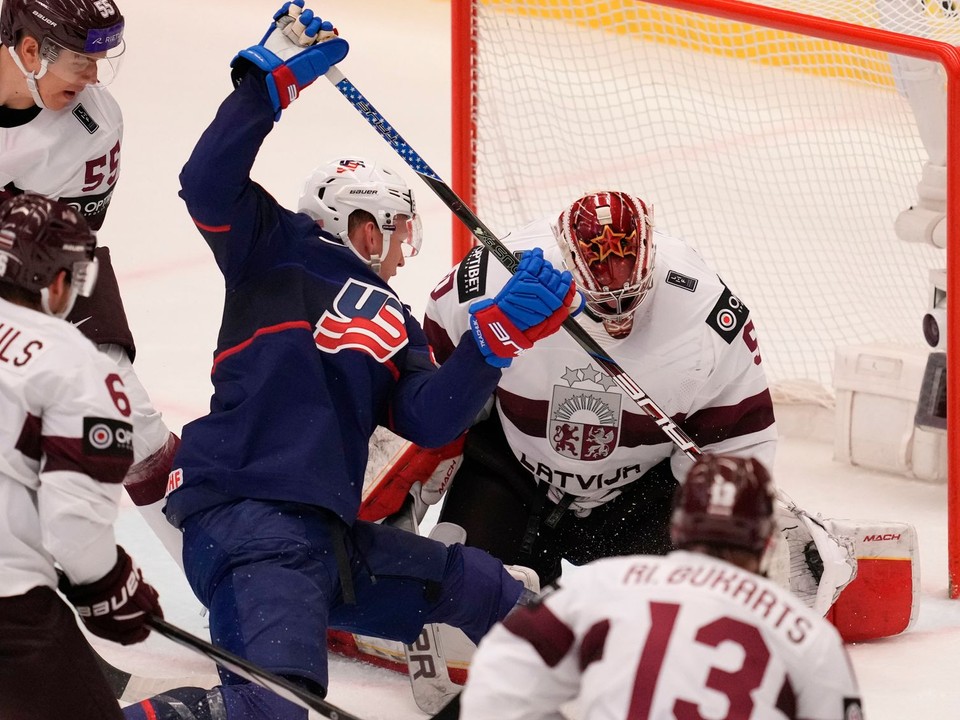 Kristers Gudlevskis a Brady Tkachuk počas zápasu Lotyšsko - USA na MS v hokeji 2024.