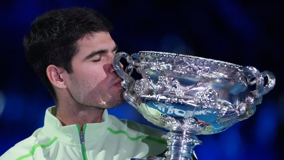 Carlos Alcaraz bozkáva trofej pre víťaza Australian Open.