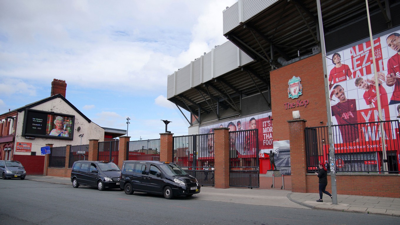 Na snímke vľavo transparent s podobizňou zosnulej britskej královnej Alžbety II. je umiestnený na jej pamiatku vedľa štadiónu Anfield, na ktorom hráva svoje domáce zápasy FC Liverpool.