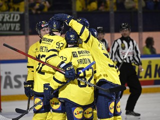 Švédski hokejisti oslavujú gól. 