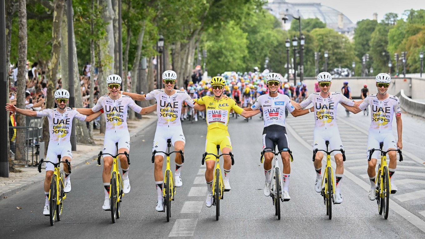 Slovinec Tadej Pogačar, oblečený v žltom drese lídra celkového poradia, oslavuje so svojimi tímovými kolegami z UAE Team Emirates.