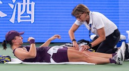Na snímke poľská tenistka Iga Swiateková leží na kurte počas ošetrenia.