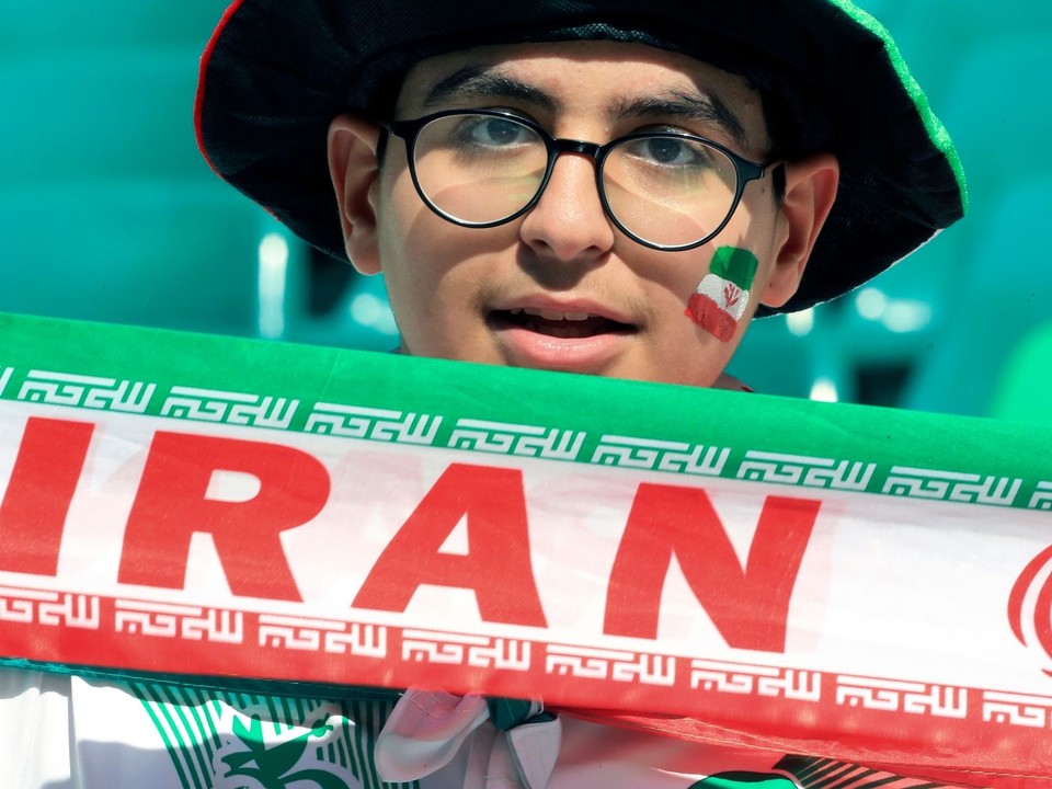 FILE - An Iranian fan holds his national team banner prior to the Asian Cup quarterfinal soccer match between Japan and Iran at Education City Stadium in Al Rayyan, Qatar, Feb. 3, 2024. (AP Photo/Hussein Sayed, file)