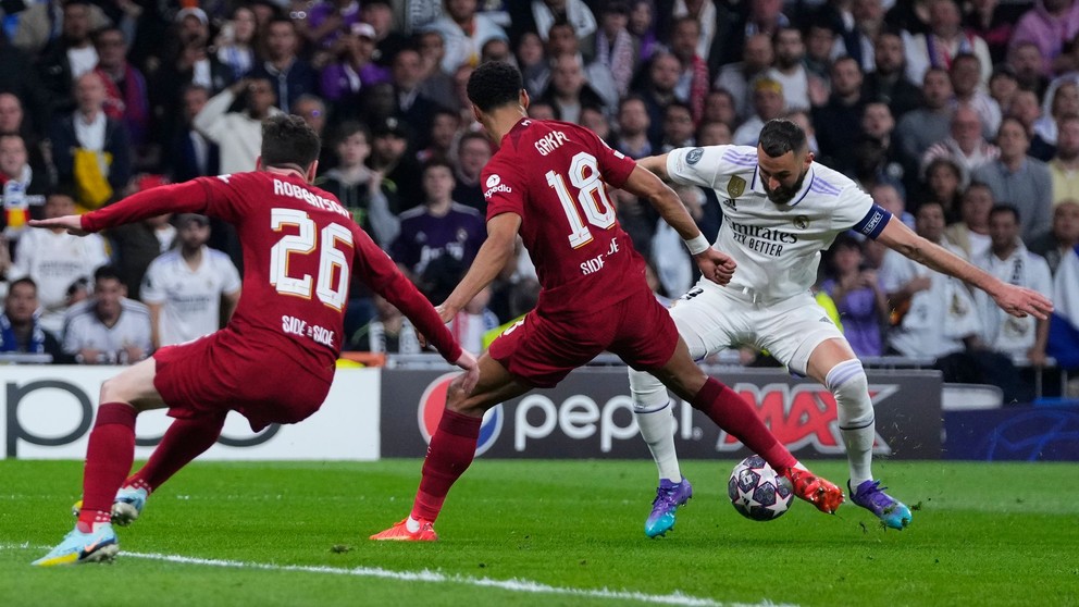 Francúzsky útočník Realu Madrid Karim Benzema v obkľúčení hráčov FC Liverpool. 