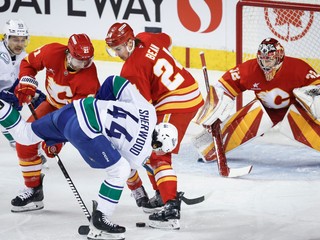 Na archívnej snímke útočník Calgary Flames Kevin Rooney (s číslom 21) v súboji o puk.