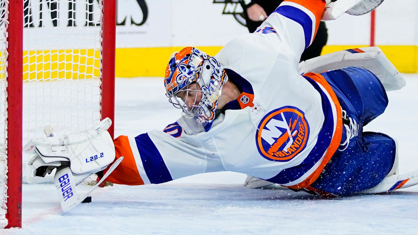 Semion Varlamov v drese New Yorku Islanders zastavuje puk na bránkovej čiare.