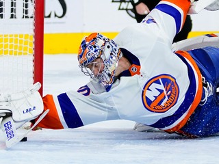Semion Varlamov v drese New Yorku Islanders zastavuje puk na bránkovej čiare.
