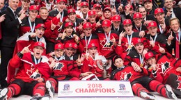 Kanadskí juniori pózujú s trofejou pre šampióna.