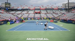Členovia sušia centrálny kurt počas prestávky spôsobenej dažďom na tenisovom turnaji v Montreale.