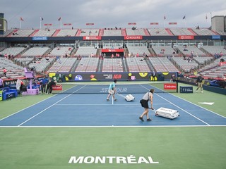 Členovia sušia centrálny kurt počas prestávky spôsobenej dažďom na tenisovom turnaji v Montreale.