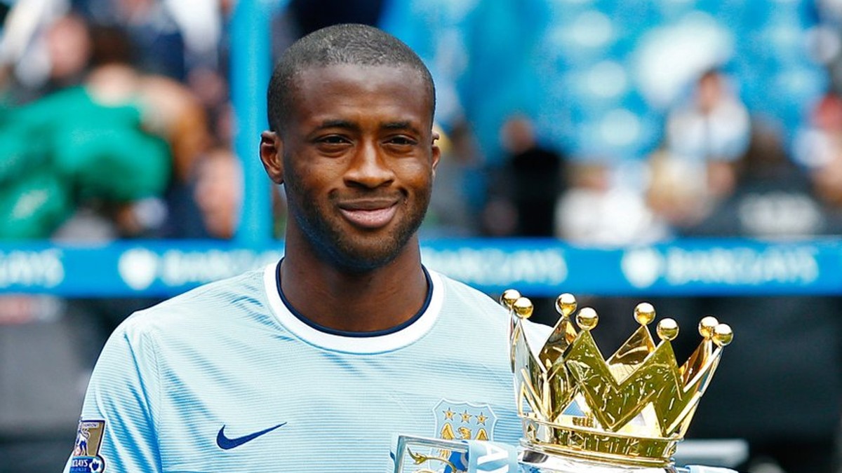 Yaya Touré v drese Manchestru City s trofejou.