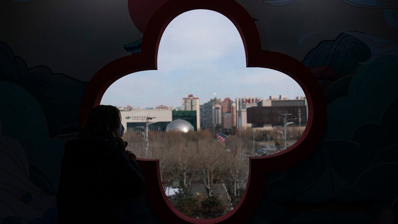Žena sa pozerá z okna na Olympijský park v hlavnom tlačovom stredisku v Pekingu.
