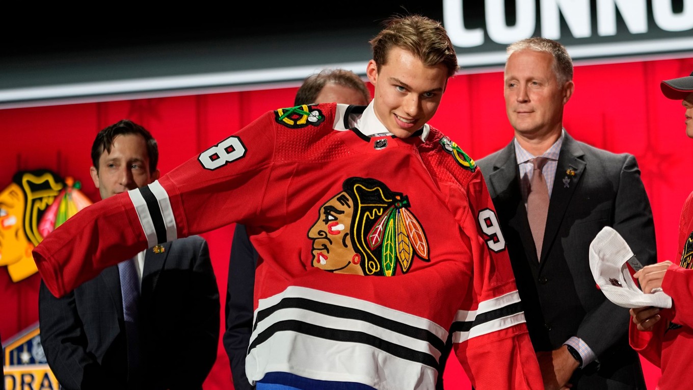 Draftová jednotka Connor Bedard si oblieka dres Chicaga Blackhawks v drafte NHL 2023.