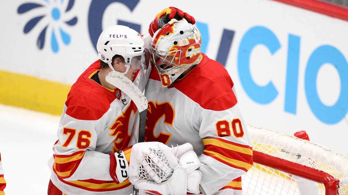 Martin Pospíšil z Calgary Flames sa teší s brankárom Danom Vladarom