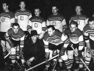 Československá hokejová reprezentácia, ktorá získala na MS 1947 titul majstrov sveta. Dolu v klobúku tréner Mike Buckna, vľavo vedľa neho Ladislav Troják.  Obaja spolu výborne vychádzali na ľade i mimo neho. 