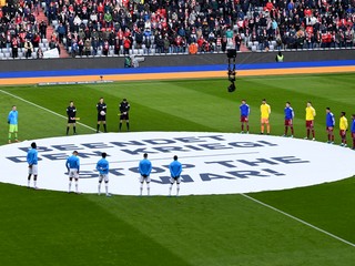 Hráči Bayer Leverkusen a Bayern Mníchov stoja počas minúty ticha pri transparente s nápisom "Zastavte vojnu" pred zápasom Bundesligy.