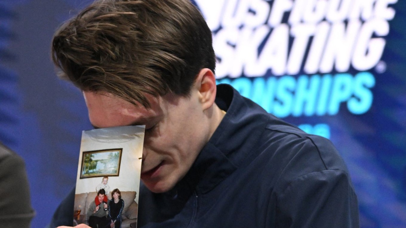 Maxim Naumov drží v ruke rodinnú fotografiu po voľnej jazde na majstrovstvách USA. 