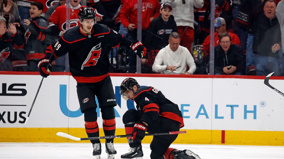 Shayne Gostisbehere (dole) a Martin Nečas sa tešia po strelenom góle v drese Carolina Hurricanes.