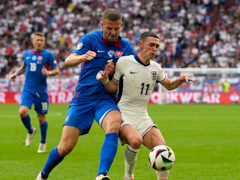 Phil Foden a Denis Vavro v súboji o loptu v zápase Slovensko - Anglicko v osemfinále EURO 2024.