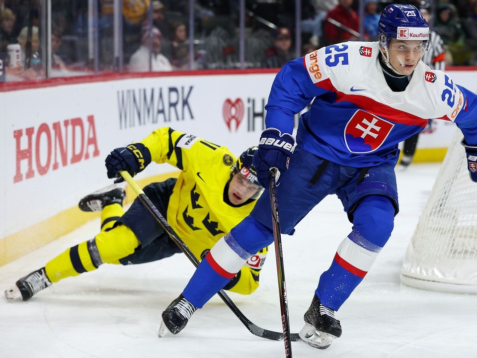 Slovenský hokejista Andrej Fabuš (vpravo) a hráč Švédska Lucas Pettersson bojujú o puk v zápase základnej A-skupiny Švédsko - Slovensko na MS hráčov do 20 rokov 2026. 